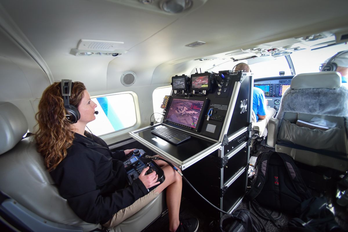 Amber Surrency of CoStar sits behind pilots Chris Swanson and Mark Beauchamp as she uses a console and remote control to operate the belly-mounted camera on the CoStar Cessna Caravan aircraft Monday, June 4, 2018, while flying over Airway Heights. (Will Campbell / The Spokesman-Review)