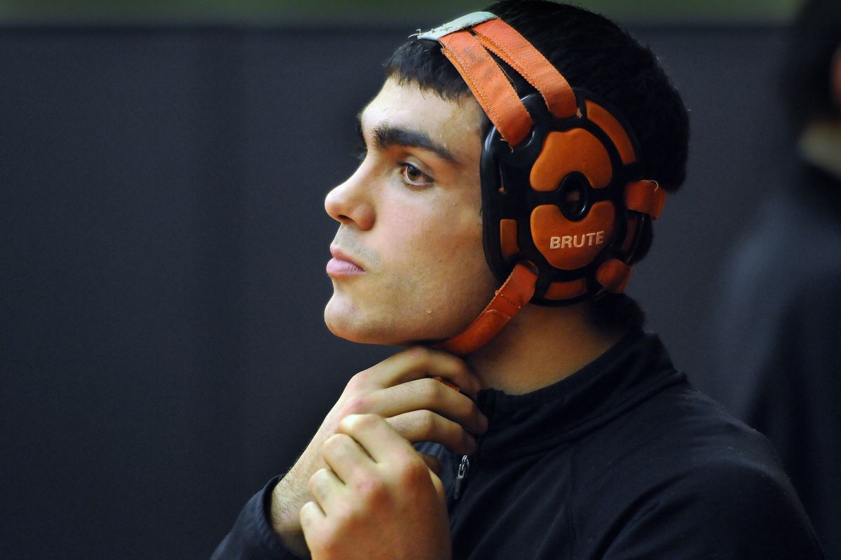 Wrestler, Devan Silva, straps on his head gear in the West Valley High School wrestling room as he warms up before his match with Pullman's Matt Lyon on Tuesday, Jan. 26, 2010. (Dan Pelle / The Spokesman-Review)