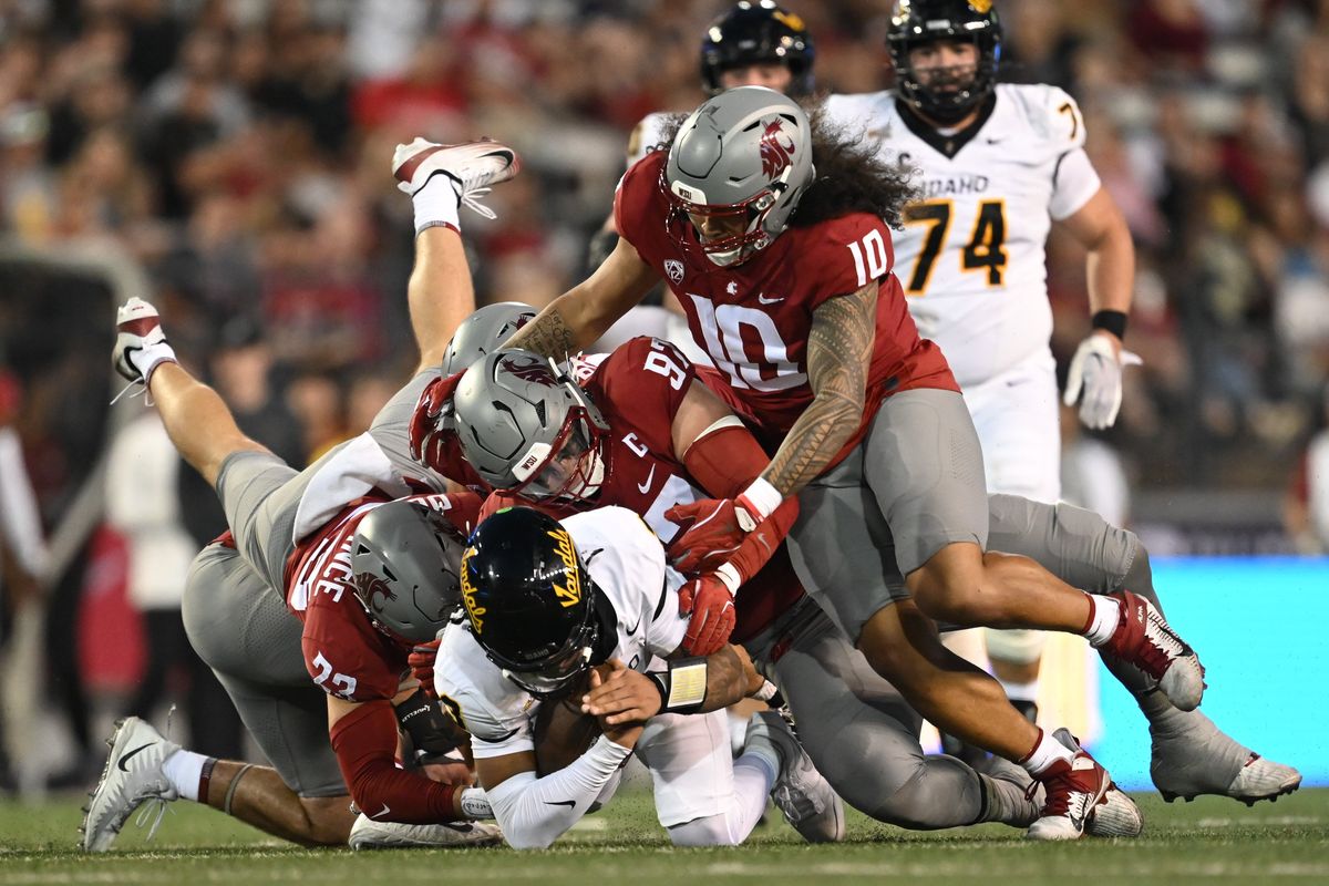 Idaho quarterback Joshua Wood is brought down by Washington State defensive tackle Max Baloun and teammates during a nonconference game on Aug. 30 at Gesa Field in Pullman.  (Tyler Tjomsland/The Spokesman-Review)