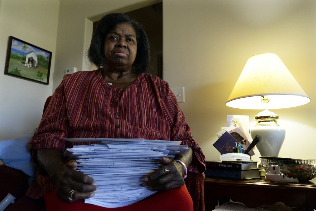 Debra Smith, 57, holds her medical bills in her living room on Thursday, Oct. 7, 2021, in Spring Hill, Tenn. Smith, who has health problems that prevent her from working, has about $10,000 in unpaid medical bills. Living expenses and prescriptions consume most of the $2,300 a month Smith gets from a pension and Social Security.  (Mark Zaleski)