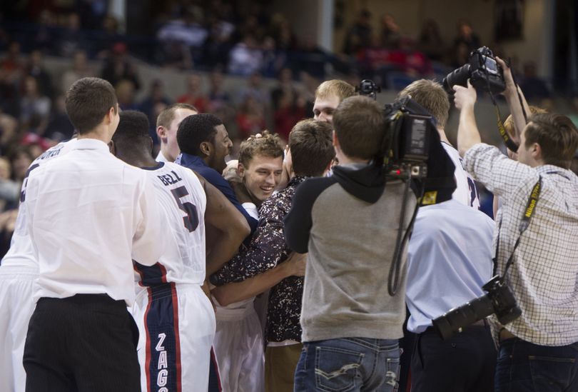 Gonzaga's bench swarms senior Brian Bhaskar, center, after he sank a 3-point shot during the final moments of Senior Night. (Tyler Tjomsland)