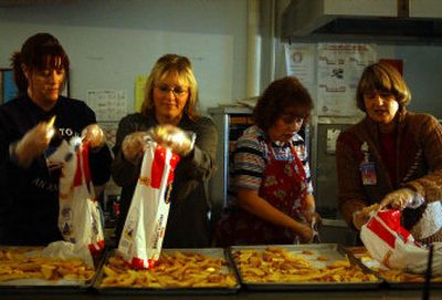 Teacher's aide Mary Sherrodd, para-educator Jeanie Eastman, school cook Melodie Lunden and Principal Anita Galland pack up potato wedges that could not be cooked for lunch Monday because of a power outage at Progress Elementary in Spokane Valley. Instead the students were treated to jam sandwiches. 
 (Liz Kishimoto / The Spokesman-Review)