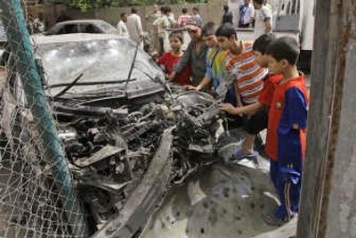 
Boys check out a car destroyed in an airstrike Tuesday in Sadr City,  which has seen fierce fighting between the Mahdi Army militia and U.S. and Iraqi troops. Associated Press
 (Associated Press / The Spokesman-Review)