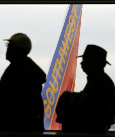 The tail of their plane appears outside the window as passengers line up to board their Southwest Airlines flight in St. Louis. Southwest Airlines had the best results for on-time arrivals last year. (File Associated Press)