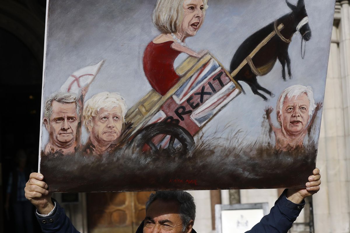 Painter Kaya Mar shows a painting at the High Court entrance on the second day of the Brexit legal challenge in London, Monday, Oct. 17, 2016. A judicial review action has been brought by British citizens who say the Government cannot trigger Article 50 of the Treaty of Lisbon - enabling the UK to leave the EU - without the prior authorization of Parliament. (Frank Augstein / Associated Press)