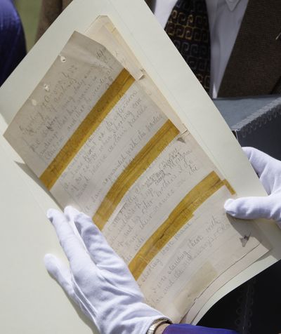 GladysAnn Wells, Director, Arizona State Library, Archives and Public Records, uses gloves to show off a page of original court transcripts from the 1881 Coroner's Inquest in the Gunfight at the OK Corral, during a news conference before the documents are handed over to the Arizona State Archives Wednesday, April 21, 2010, in Phoenix. The 36-page hand-written account of witness testimony given after the shootout that left three men dead in Tombstone, Ariz., had been missing for years, until found by two court clerks cleaning out storage space at the Bisbee, Ariz., courthouse in March. (Ross Franklin / Associated Press)