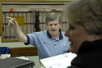 
U.S. Postal clerk Delmar Garrod assists a customer at the Shadle/Garland Station. Garrod assisted a man who was being defrauded by a scheme designed to target elderly adults' financial resources. 
 (Dan Pelle / The Spokesman-Review)