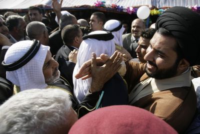 An Iraqi Sunni, left, and Shiite  shake hands during an opening ceremony for the Imams Bridge in northern Baghdad on Tuesday.  (Associated Press / The Spokesman-Review)