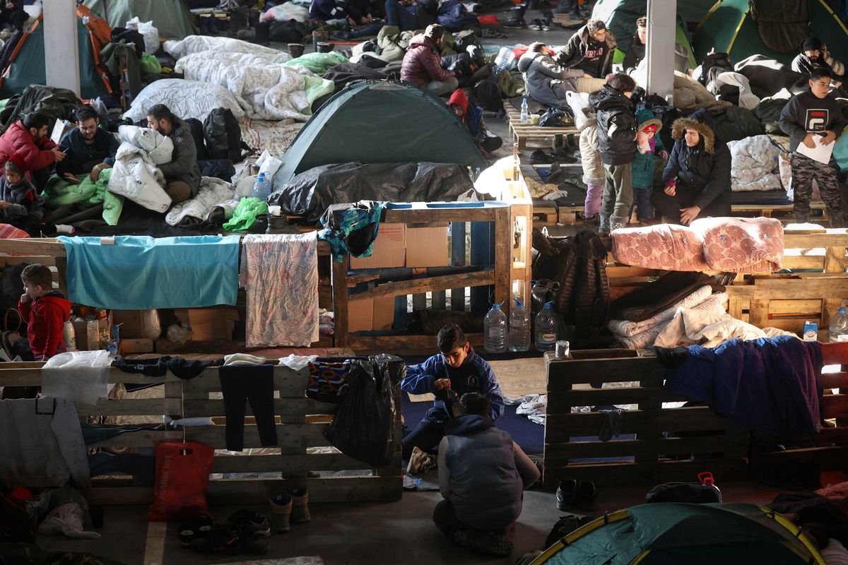 Migrants settle in the logistics center of the checkpoint "Bruzgi" at the Belarus-Poland border near Grodno, Belarus, Wednesday, Dec. 1, 2021. The West has accused Belarusian President Alexander Lukashenko of luring thousands of migrants to Belarus with the promise of help to get to Western Europe to use them as pawns to destabilize the 27-nation European Union in retaliation for its sanctions on his authoritarian government. Belarus denies engineering the crisis.  (Oksana Manchuk)