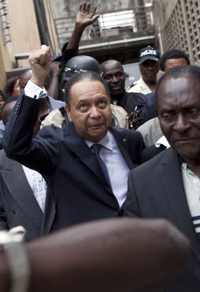 Haiti’s ex-dictator Jean-Claude Duvalier gestures to supporters as police take him out of his hotel in Port-au-Prince, Haiti, on Tuesday.  (Associated Press)