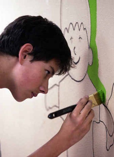 
David Wiser, 16, paints the grassy background on the north facing wall in the new pizza playground at Players & Spectators. Vong Xiong designed the mural.
 (Liz Kishimoto/The Spokiesman-Review / The Spokesman-Review)