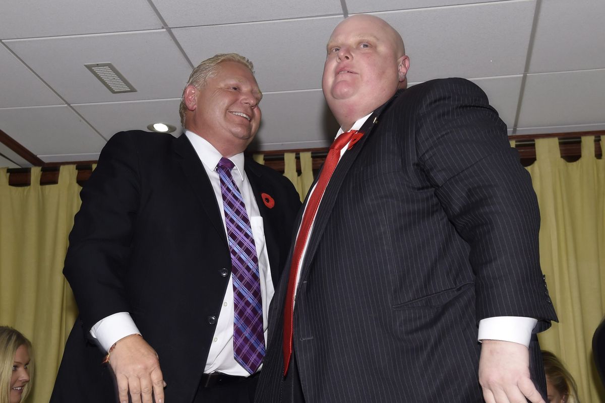 Toronto Mayor Rob Ford, right, consoles his brother, mayoral candidate Doug Ford, left, at their mother’s home in Toronto on Monday, after John Tory was declared the winner of the election. (Associated Press)