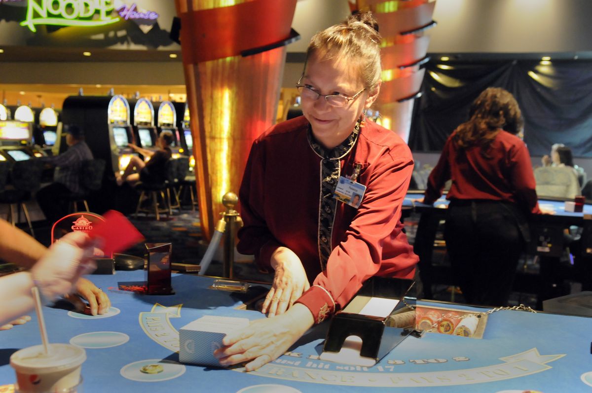 Dealer Rebecca Williams offers the cards to a player for a cut before reloading the “shoe” and dealing  at the blackjack tables on May 28 at Northern Quest Casino. The casino complex is among the fastest-growing businesses in the area. jesset@spokesman.com (Photos by JESSE TINSLEY jesset@spokesman.com / The Spokesman-Review)
