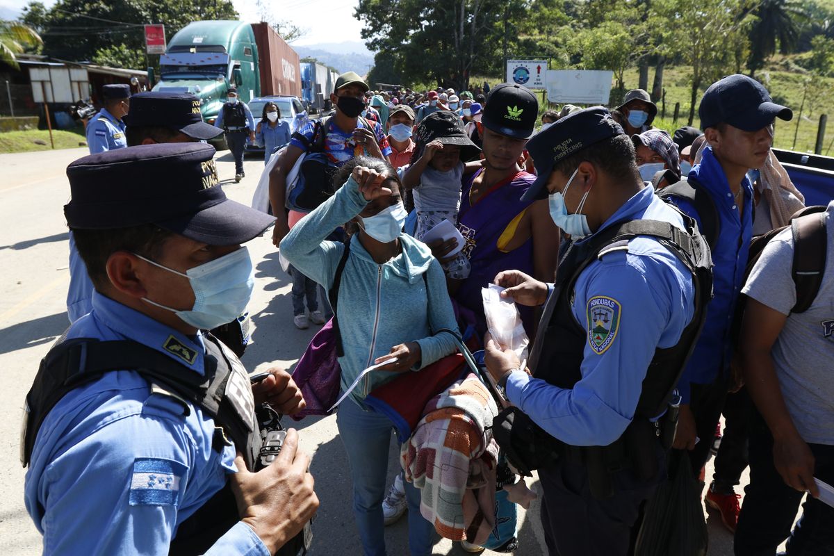 Honduran police check documents of migrants who are part of a caravan hoping to reach the United States, in Corinto, Honduras, Saturday, Jan. 15, 2022.  (Delmer Martinez)
