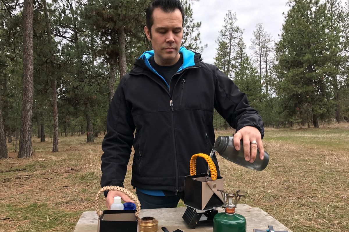 Cory Santiago pours water into a Bear Bowl. The square camping cook pots are fold-able, fireproof and fit in your pocket. (Courtesy of Bear Minimum)