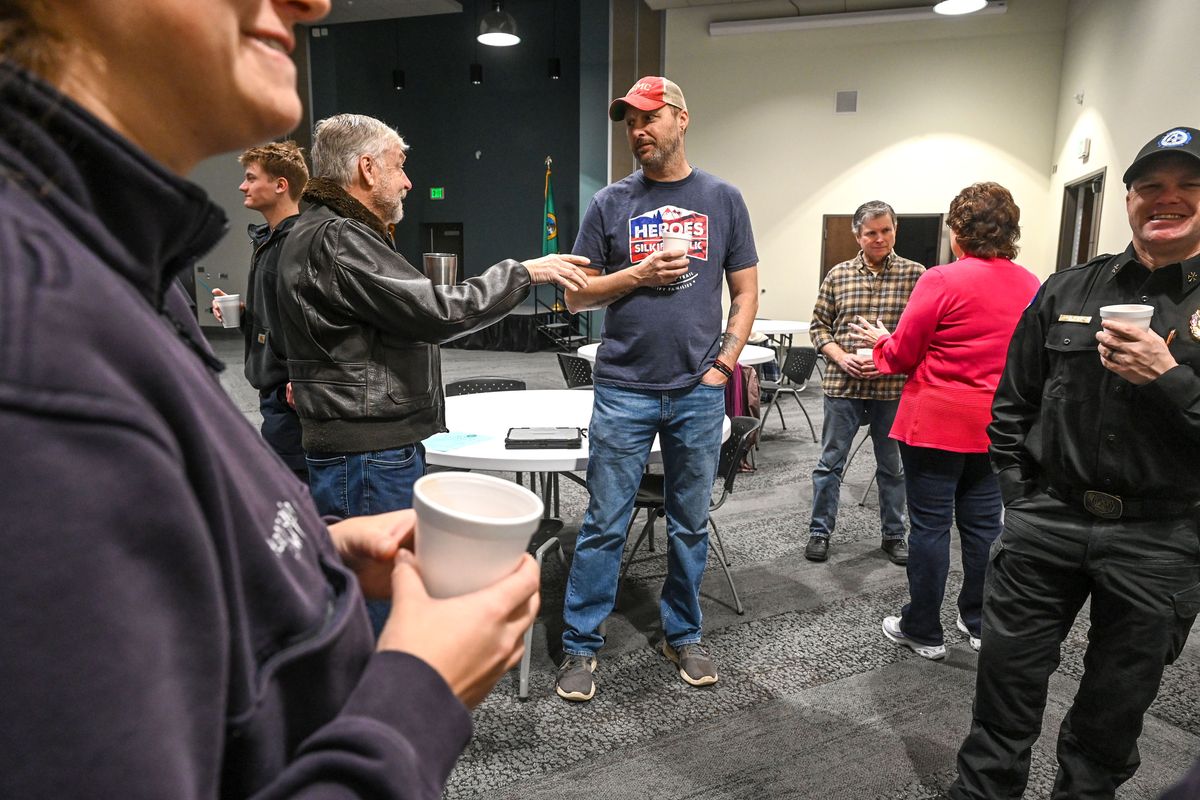 Navy veteran and Spokane County Fire District support services member, Walt Seidel, center left, talks with Marine Corps veteran, Ryan Finnegan, also a support service member, center in the hat, during a Heroes Connect gathering of firefighters, EMS and military on Jan. 19 in the Spokane County Fire District 4 community room in Deer Park. At right rear in the plaid shirt, Army veteran Don McConnell talks with Kathy Colkitt, of Homes for Heroes, in the red top.  (DAN PELLE/THE SPOKESMAN-REVIEW)