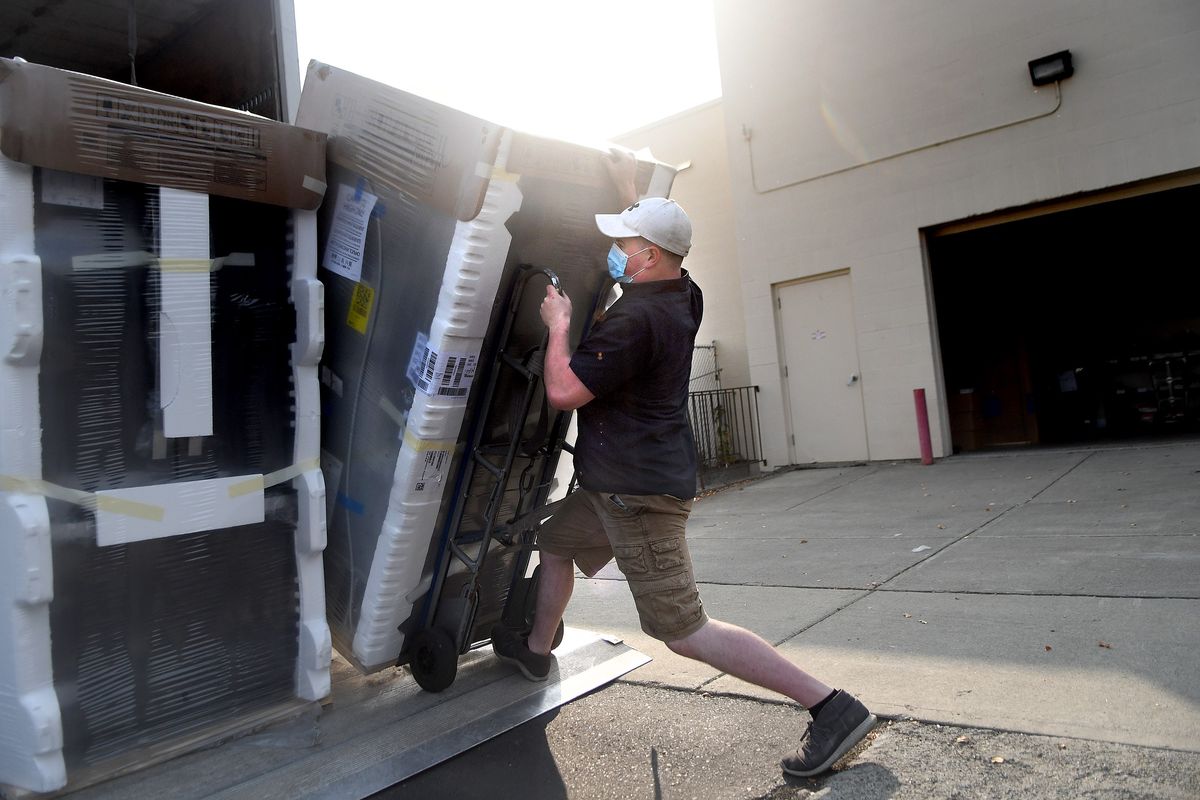 John Roehrman of Fred’s Appliance unloads refrigerators at a store in Spokane on Thursday. A combination of unexpected demand and slowed manufacturing has caused delays in the delivery of many appliances.  (Kathy Plonka/The Spokesman-Review)