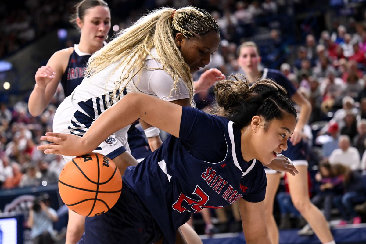 Saint Mary’s guard Zeryhia Aokuso loses the ball after a collision in the paint with Gonzaga forward Yvonne Ejim during a Feb. 20 Zags victory at McCarthey Athletic Center. (TYLER TJOMSLAND)