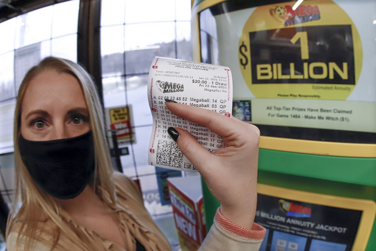 A patron, who did not want to give her name, shows the ticket she had just purchased for the Mega Millions lottery drawing at the lottery ticket vending kiosk in a Smoker Friendly store, Friday, Jan. 22, 2021, in Cranberry Township, Pa. The jackpot for the Mega Millions lottery game has grown to $1 billion ahead of Friday night
