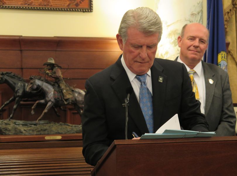 Idaho Gov. Butch Otter signs HB 463, major tax-cut legislation, into law on Monday, March 12, 2018; at right is House Majority Leader Mike Moyle, R-Star, a major proponent of the bill. (The Spokesman-Review / Betsy Z. Russell)