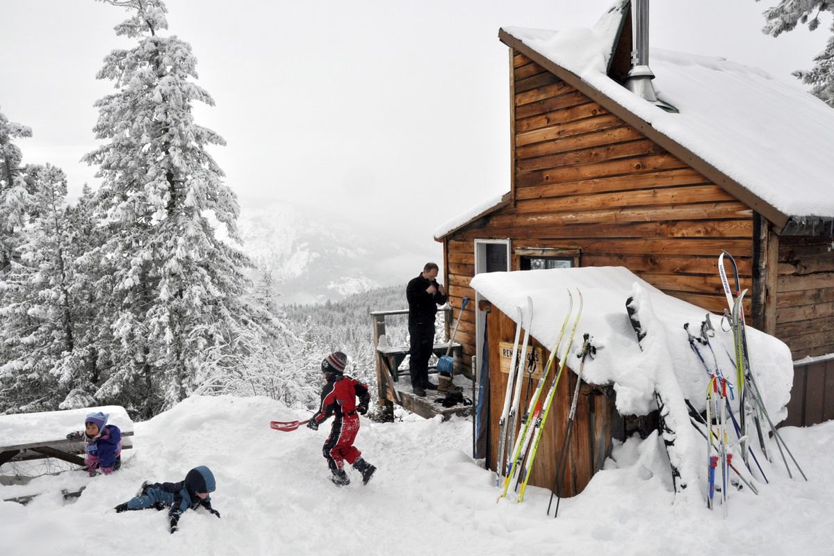 From left, Zola Barnwell and Dashiell and Karsten Stucke make good use of their snow time while John Stucke, right, and other parents get ready for skiing from one of five backcountry huts available for rent in the Methow Valley. The wood-heated huts are among the wide range of basic to luxury accommodations along the Methow Valley Sport Trails Association trails. (Rich Landers)