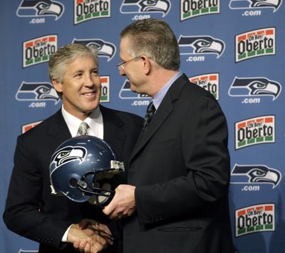 New Seattle coach Pete Carroll, left, and Seahawks CEO Tod Leiweke shake hands Tuesday.  (Associated Press)
