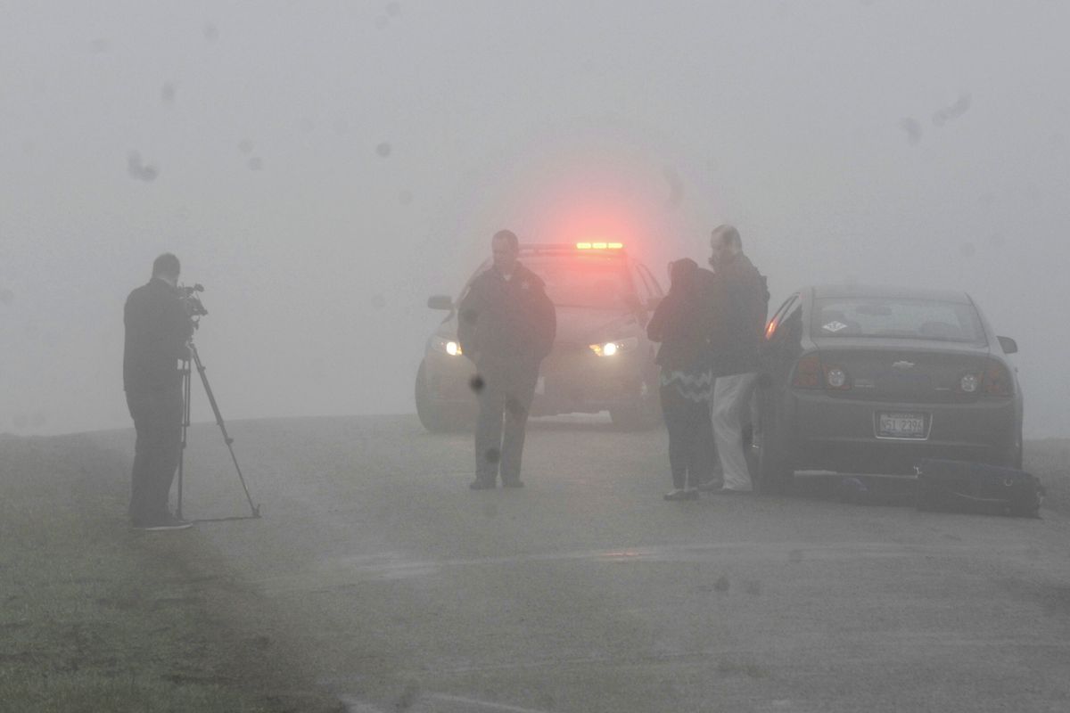 Emergency personnel and media gather at the scene near Bloomington, Ill., where a small plane, with at least five on board, crashed early Tuesday, April 7, 2015. The Federal Aviation Administration says the Cessna 414 crashed just short of the Bloomington airport after midnight Tuesday while returning from the NCAA college basketball championship in Indianapolis. (David Proeber / The Pantagraph)