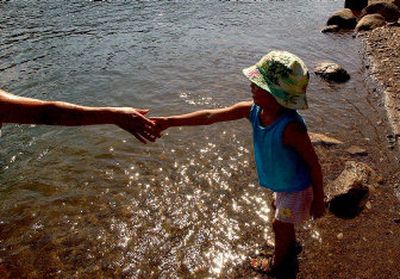 
Three-year-old Deidra Tso of Post Falls takes her mother's hand while stepping into the Spokane River during the 90-degree weather on Wednesday.
 (Kathy Plonka / The Spokesman-Review)