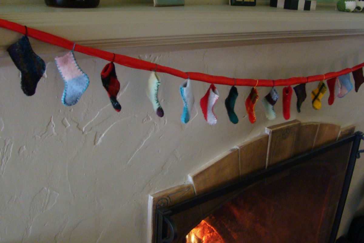 Finished advent garland--tiny stockings made from old sweaters. (Maggie Bullock)