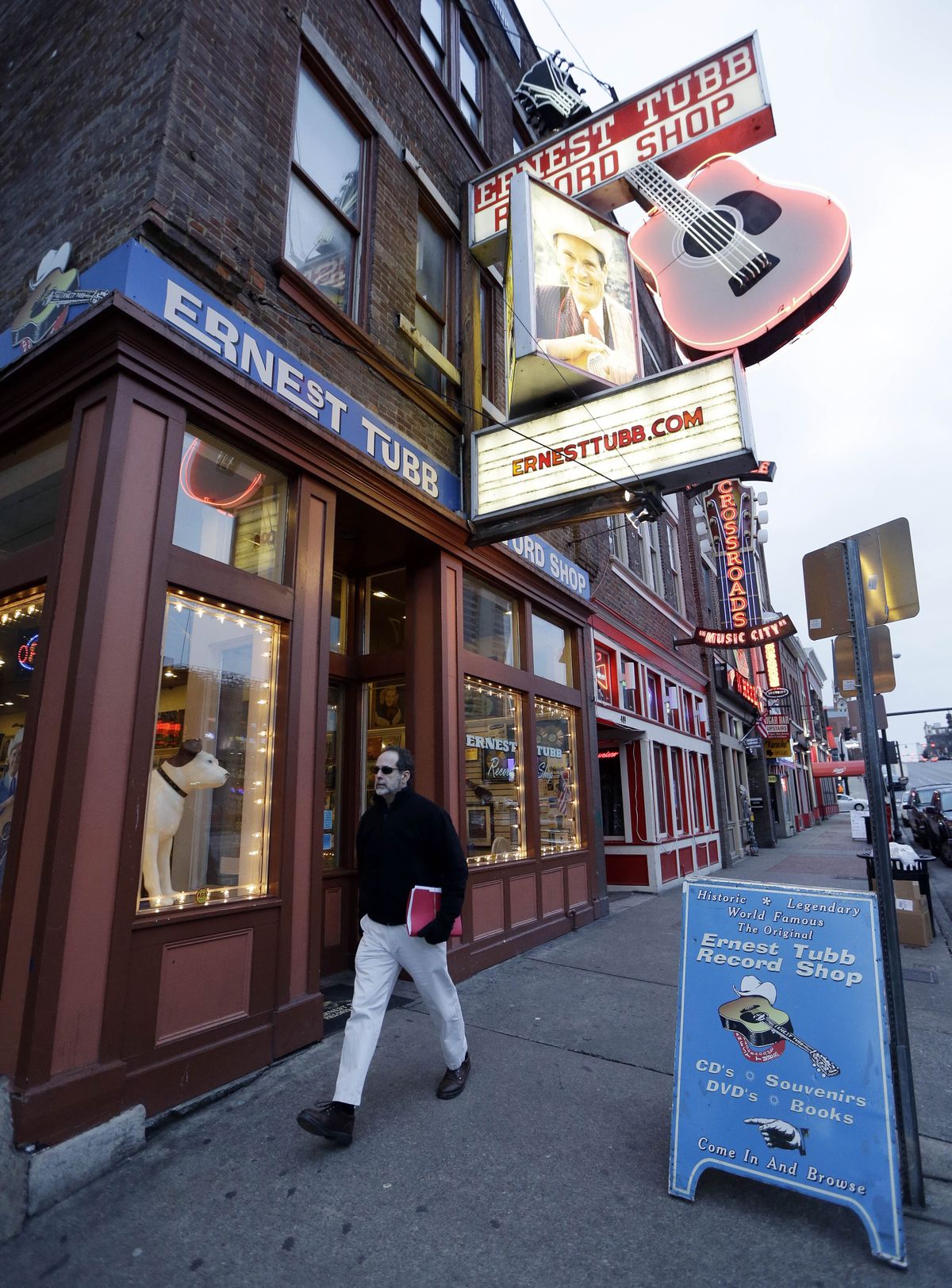 FILE - A pedestrian walks by the Ernest Tubb Record Shop in Nashville, Tenn., on Jan. 15, 2014. The Nashville record store that was opened by Opry legend Ernest Tubb in 1947 will close as the building is being put up for sale. Owners announced on Friday that the shop on Broadway will close in the spring after being in its current location since 1951, citing circumstances “beyond our control.” (Mark Humphrey)
