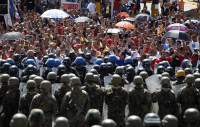 Supporters of ousted Honduras President Manuel Zelaya raise their fists as they face  a line of Honduran army soldiers and police at the entrance to the international airport in Tegucigalpa on Saturday.  (Associated Press / The Spokesman-Review)