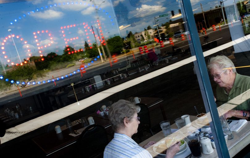 Jan and Jack Hamlin enjoy lunch at Donna’s Diner as Sprague Avenue reconstruction is seen reflected in the window Wednesday. (Tyler Tjomsland)