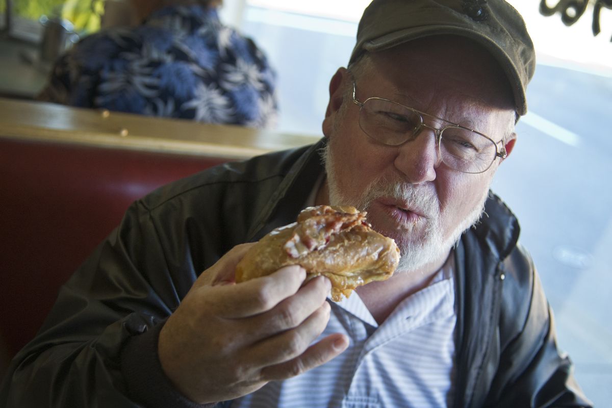 Richard Hodge, a 30-year regular at the Donut Parade, takes a bite of the new top selling Flatliner. (Colin Mulvany)