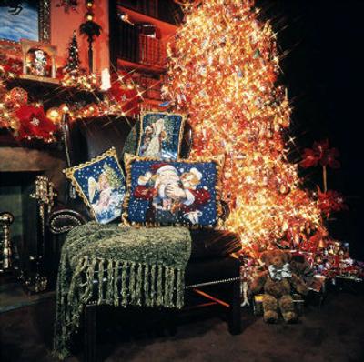 
In front of a Christmas tree ablaze with lights and ornaments, needlepoint cushions by Christopher Radko sparkle with holiday themes and add spirit to an easy chair. 
 (File/Associated Press / The Spokesman-Review)