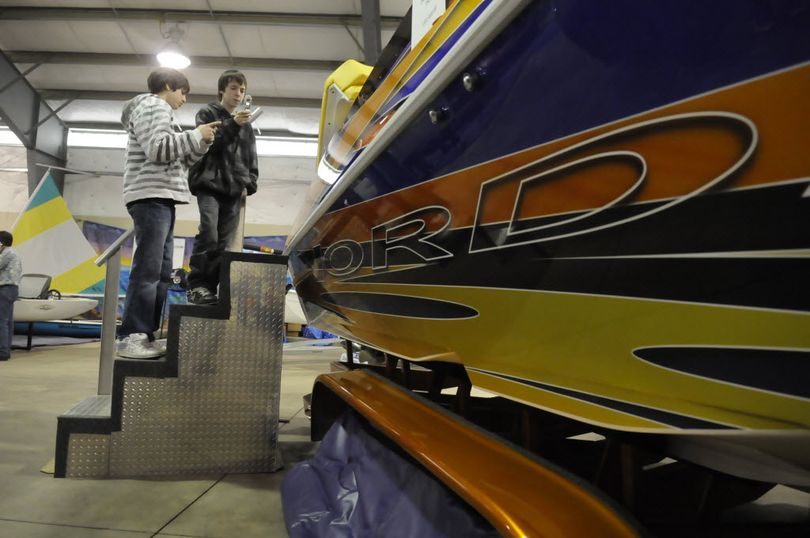 Austin Andersen, 13, left, and Micah Smith, 14, use their cell phones to document a large Nordic speedboat powered by twin Chrysler Viper engines at the Spokane Boat Show Saturday, Jan. 30, 2010 at the Spokane Fair and Expo Center. Hundreds of boats, from kayaks to large cruisers, are on display, along with accessories like skis, fishing tackle and boat docks.   (Jesse Tinsley)