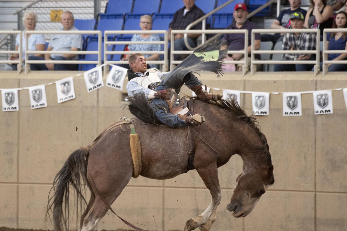 Clay Stone, from Blackfoot, Idaho completes his ride but works at extricating his right hand from the rigging in order to get off his bareback bronc Friday, Sept. 7, 2018. Stone was participating in the PRCA Rodeo program at the Spokane County Interstate Fair. (Jesse Tinsley / The Spokesman-Review)