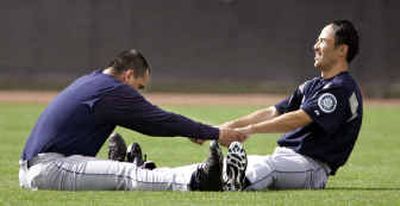 
Seattle Mariners pitchers Eddie Guardado, left, and Shigetoshi Hasegawa use each other as leverage as they stretch during Tuesday's spring training workouts in Peoria, Ariz. 
 (Associated Press / The Spokesman-Review)