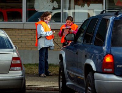
Pasadena Elementary School fifth-graders Ellen Postlewait, 11, left, and Sarah Marro, 10, time and record an idling car in the school parking lot on Wednesday as part of a project with the Spokane County Air Pollution Control Authority. 
 (Liz Kishimoto / The Spokesman-Review)