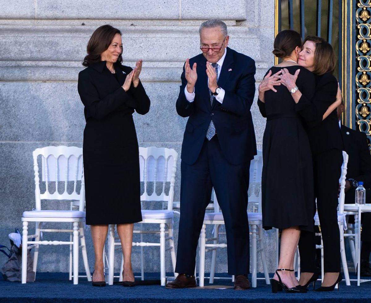 Eileen Mariano, granddaughter of Sen. Dianne Feinstein, hugs House Speaker Emerita Nancy Pelosi as Vice president Kamala Harris and Senate Majority Leader Chuck Schumer applaud during Feinstein