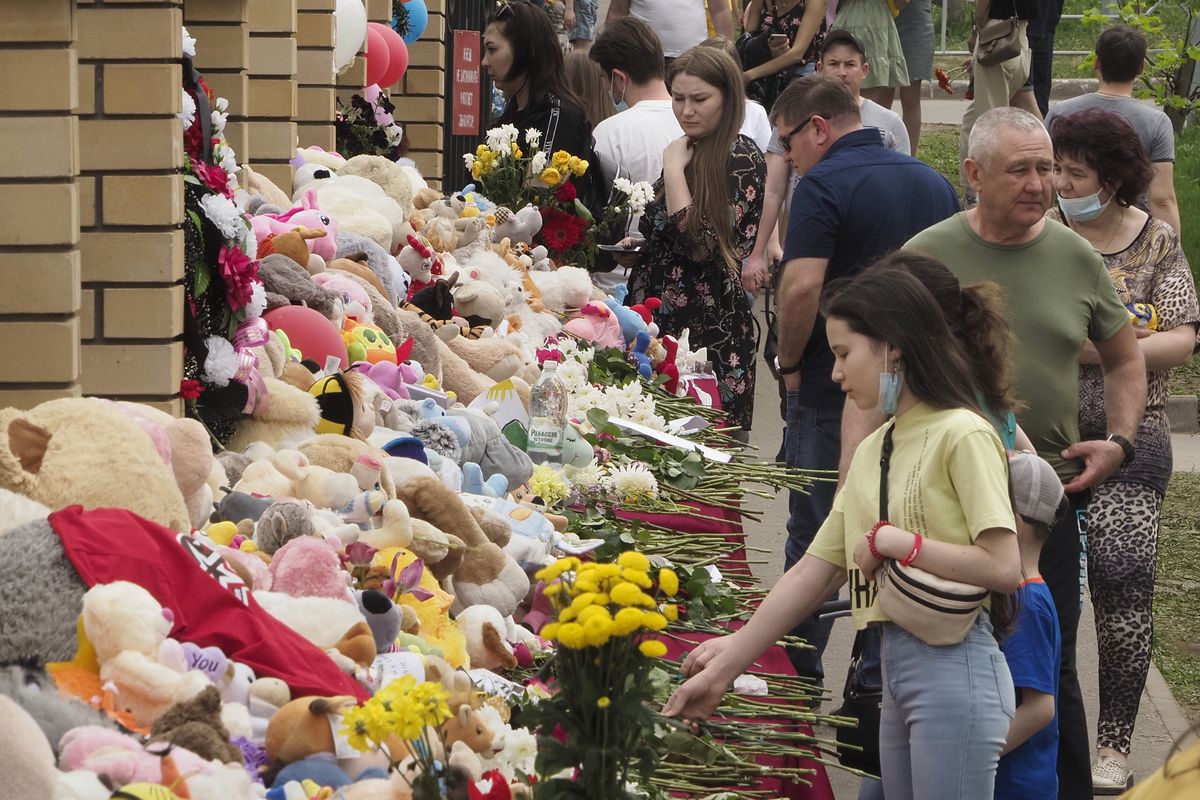 People lay flowers and toys near a school after a shooting on Tuesday in Kazan, Russia, Thursday, May 13, 2021. Russian officials say a gunman attacked a school in the city of Kazan and Russian officials say several people have been killed. Officials said the dead in Tuesday