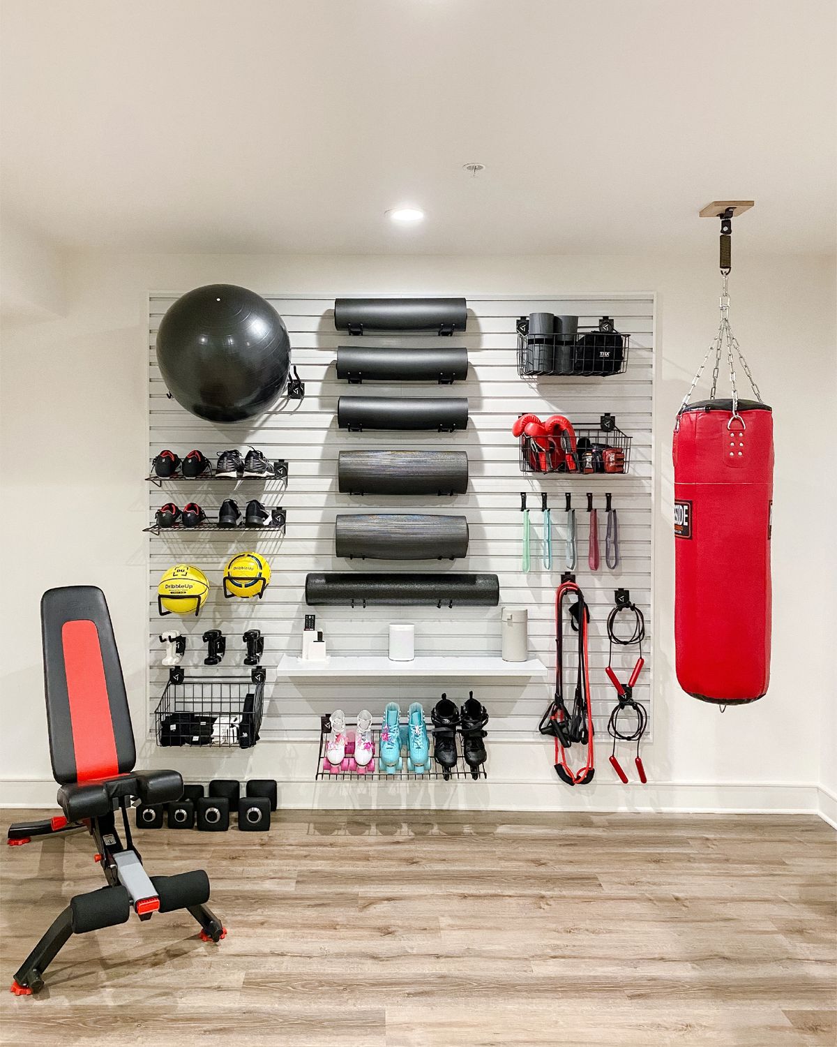 The Gladiator Slat Wall was used to organize the elements of a home gym in a project by Settled, a home organizing company in New York.  (Settled)