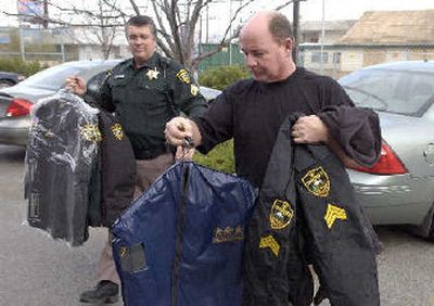 
Spokane Valley Police Chief Cal Walker gives his uniforms to patrol Sgt. Dave Martin on Tuesday.  Martin said he'll  