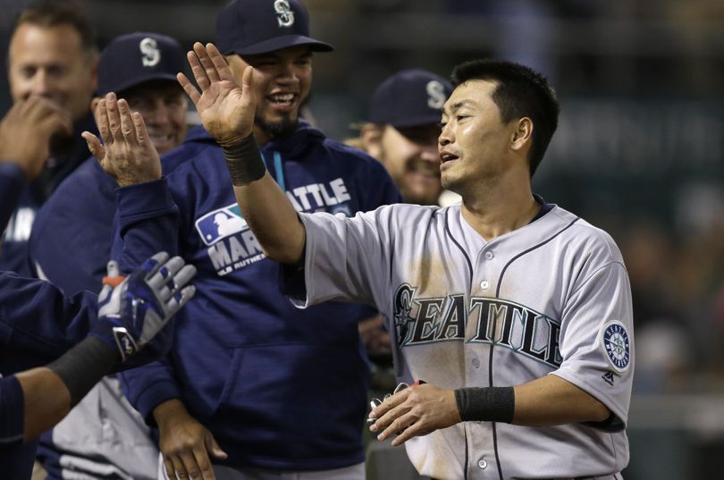 Norichika Aoki is congratulated after scoring the winning run for the Mariners against Oakland  in the seventh inning Monday night. (Ben Margot / Associated Press)