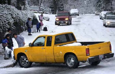 
Onlookers and children waiting for a school bus watch Tuesday as a pickup slides sideways down Sixth Avenue, narrowly missing a fire hydrant. 
 (Holly Pickett / The Spokesman-Review)
