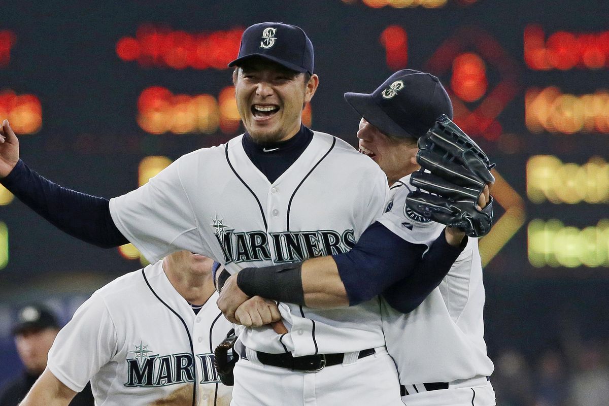 Seattle Mariners starting pitcher Hisashi Iwakuma is hugged by first baseman Logan Morrison, right, after the final out of Iwakuma