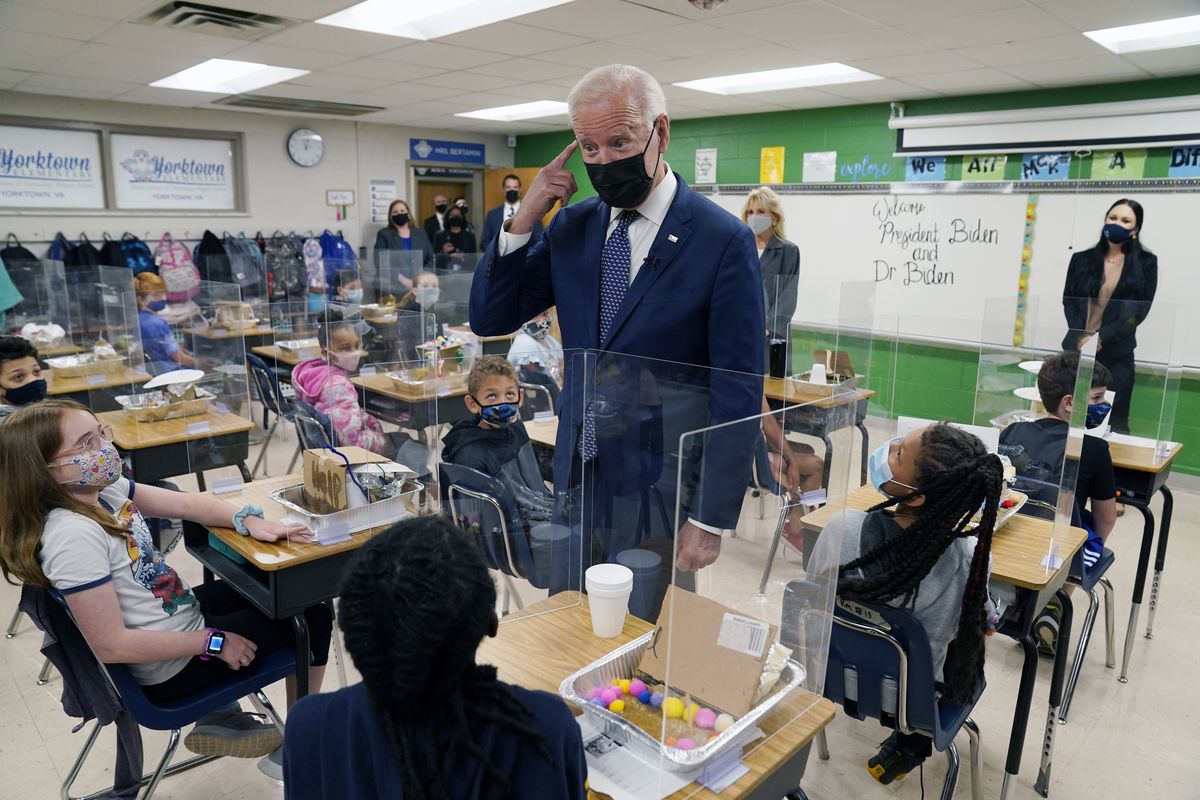 In this May 3, 2021, photo, President Joe Biden gestures as he talks to students during a visit to Yorktown Elementary School, in Yorktown, Va., as first lady Jill Biden watches. Biden has met his goal of having most elementary and middle schools open for full, in-person learning in his first 100 days.  (Evan Vucci)