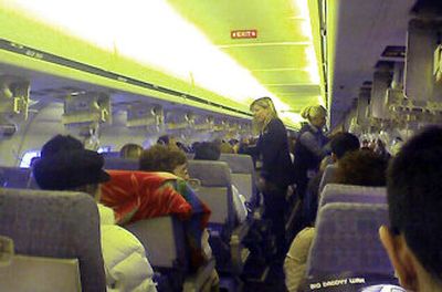
In this Dec. 26 photo taken by airline passenger Jeremy Hermanns, Alaska Airlines flight 536 flight attendants talk to passengers after the plane lost pressure. The MD-80 lost cabin pressure at 26,000 feet because of a foot-long gash in its fuselage. 
 (FILE Associated Press / The Spokesman-Review)