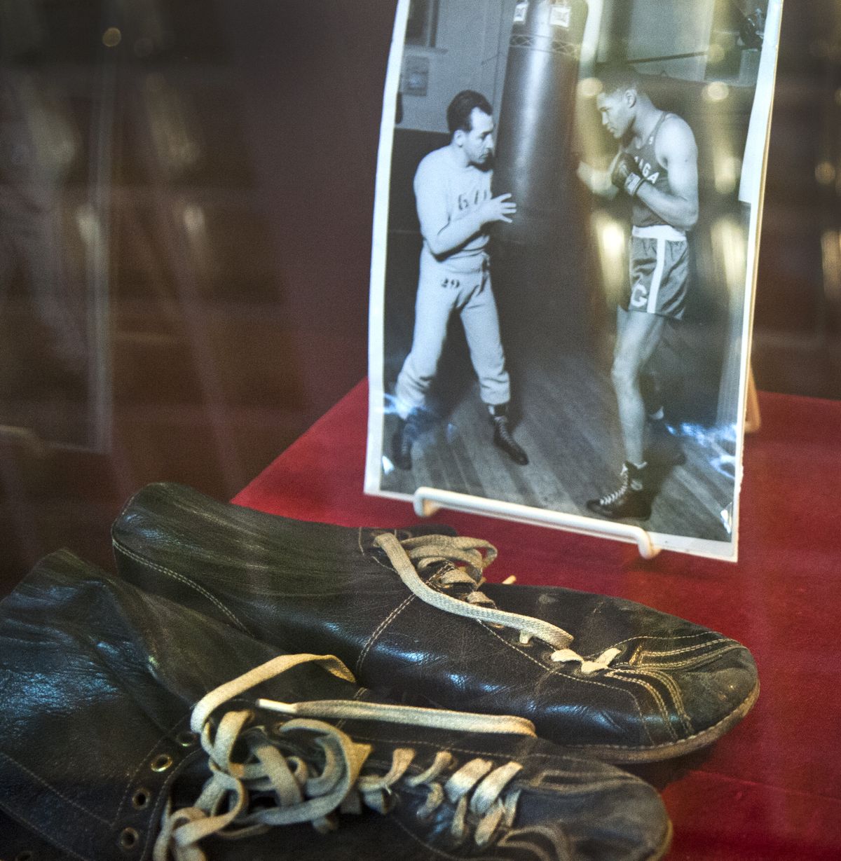 A 1949 photo of Gonzaga boxing great Carl Maxey and his coach, Joey August, is on display with Maxey’s 1950 boxing shoes. Maxey, a law student, finished his college career 32-0 and went on to become a prominent attorney. (Dan Pelle)