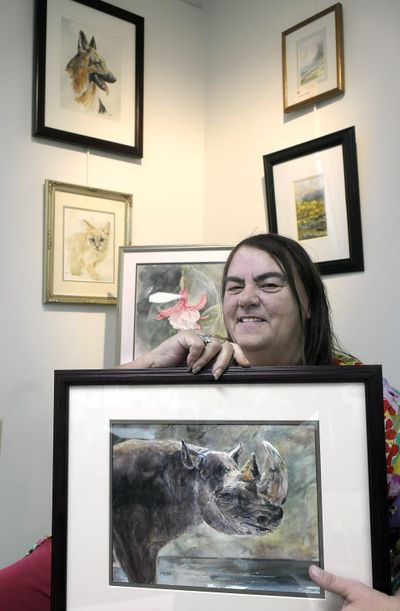 Shirley Bird-Wright holds one of her favorite artworks of a rhinoceros as she is framed with her other art at Spokane Art Supply on north Monroe Street in Spokane, Tuesday. (CHRISTOPHER ANDERSON / The Spokesman-Review)