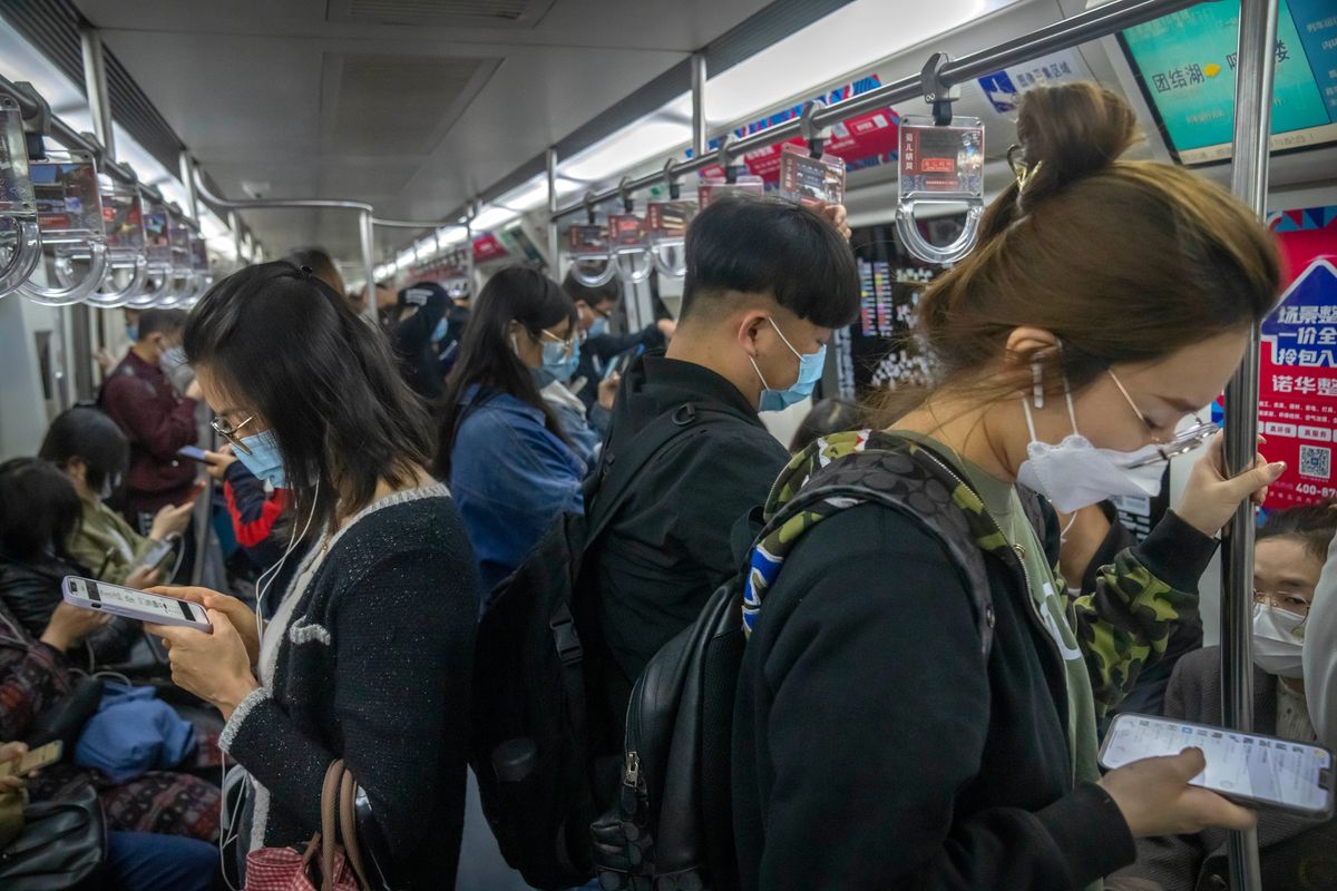 Commuters wearing face masks ride a subway train in Beijing, Tuesday, April 12, 2022. The U.S. has ordered all non-emergency consular staff to leave Shanghai, which is under a tight lockdown to contain a COVID-19 surge.  (Mark Schiefelbein)